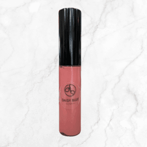 A tube of Flawless Glow Blush with a black cap and pink gloss stands upright on a white marble background.
