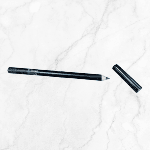 A black eyebrow pencil labeled "BROW" rests on white marble next to a Flawless Glow Blush compact, with its cap removed and set beside the pencil.