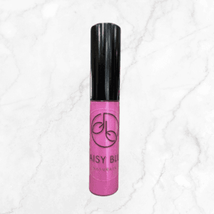 A tube of pink lip gloss with a black cap, featuring the "Daisy Blu Naturals" logo, stands upright on white marble—an ideal match for your Flawless Glow Blush to achieve a radiant look.