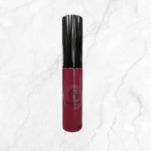 A tube of Daisy Blue liquid lipstick with a black cap and deep pink shade stands upright on white marble—ideal to pair with Flawless Glow Blush for a radiant finish.