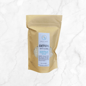 A brown resealable pouch labeled "DETOX Bath Salts" rests on a white marble surface. The label showcases benefits and ingredients, featuring natural hemp and copaiba, ideal for a soothing, restorative bath soak.