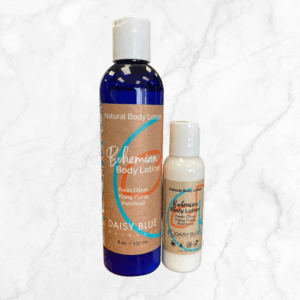 Two Bohemian Body Lotion bottles—one 8 oz and one small—are arranged on white marble. They feature blue and white bottles with orange labels.