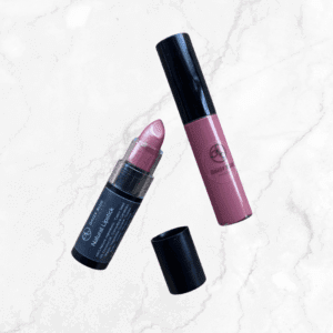 A pink shimmery lipstick with its cap off and a mauve liquid lipstick from the Hibiscus & Berry Mauvelous Lipstick & Lip Gloss Duo sit on white marble. Both feature black caps and branding on their packaging.